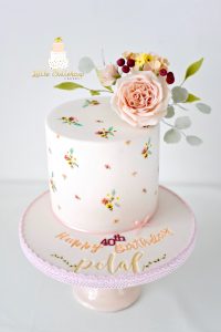 Hand painted cake adorned with sugar flowers
