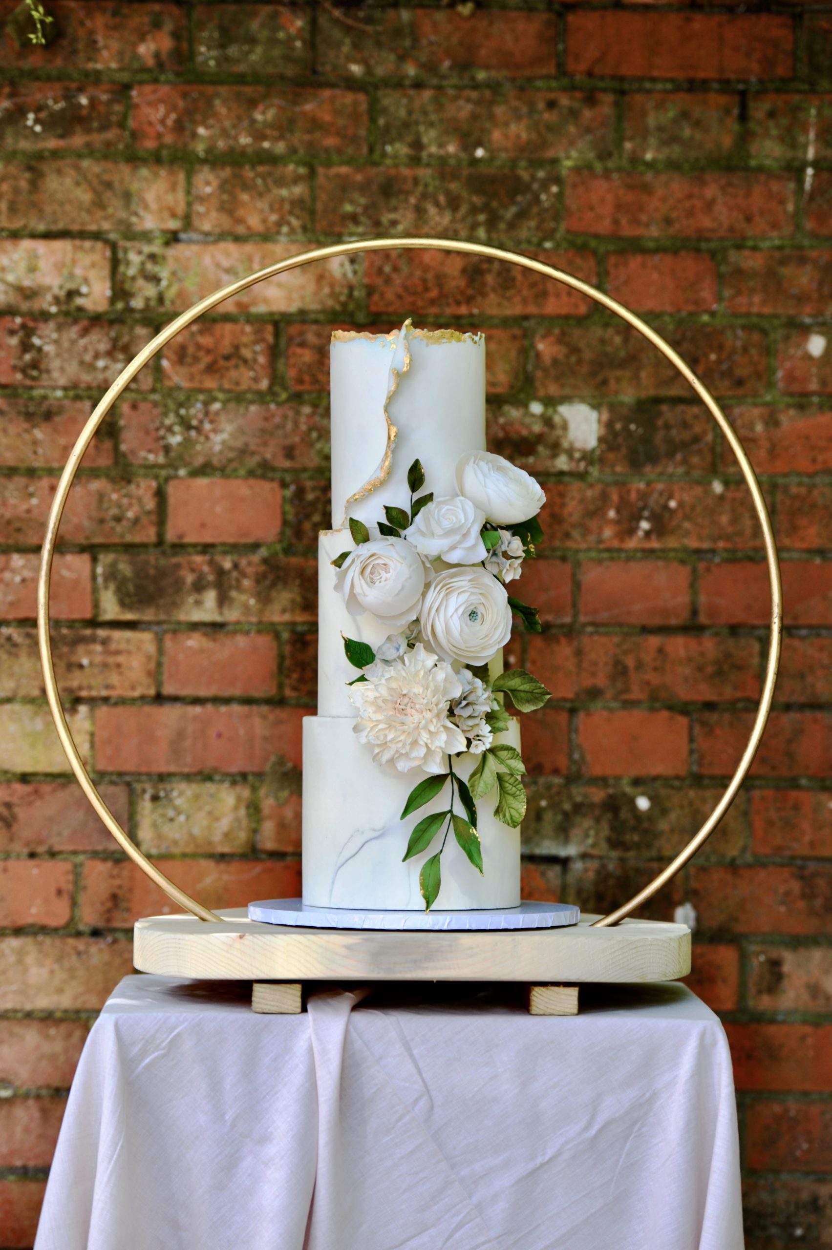 Small gold hoop & round pale wooden plinth